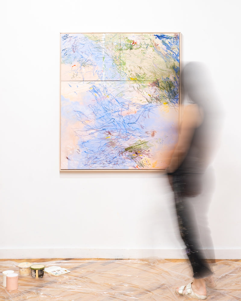 Abstract painting on a white wall with a blurred person in the foreground