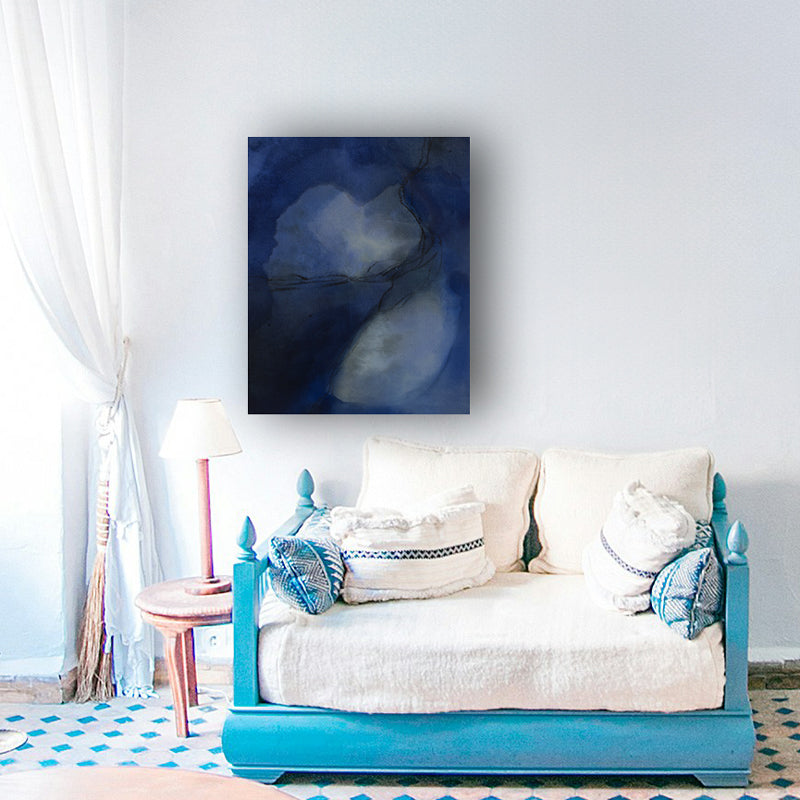 A blue abstract painting hangs above a blue and white loveseat