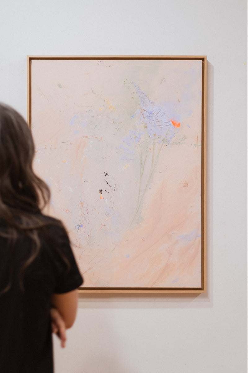 Person looking at an abstract painting on a wall