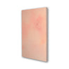 The side of a subtle abstract painting with acrylic washes of salmon pink and orange.